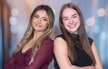 Anida Alić und Vanessa Socher vor einem bunten Hintergrund