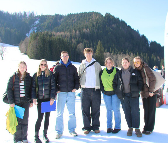Gruppe steht im verschneiten Bodental vor Bergen beim Wintersporttag