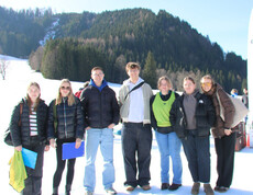 Gruppe steht im verschneiten Bodental vor Bergen beim Wintersporttag