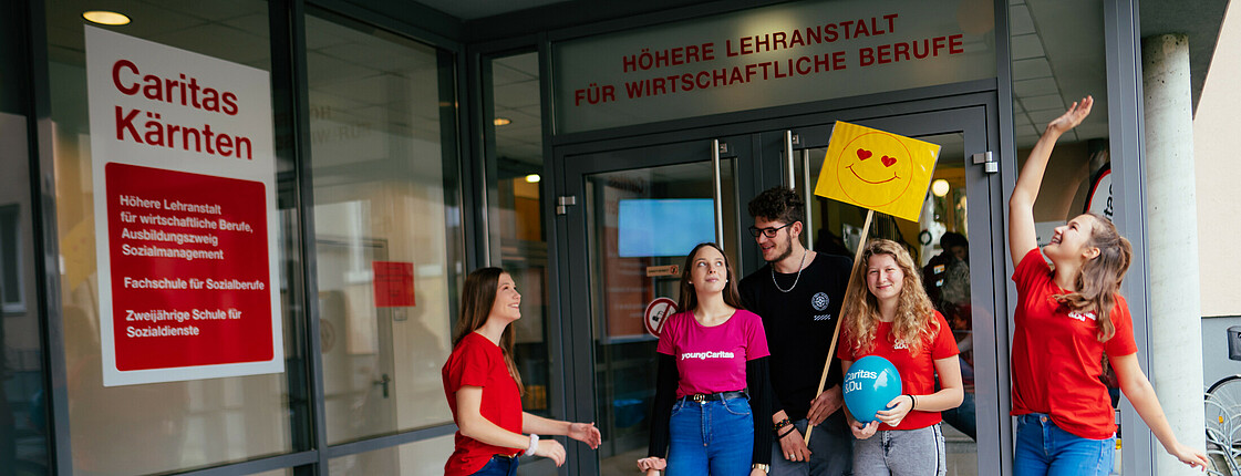 Schüler*innen stehen vor dem Eingang der Schule.